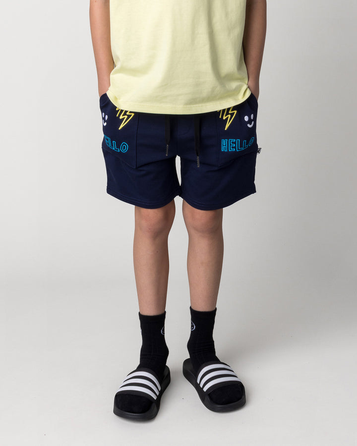 Kid wearing the Badges Short in ink, front view close up