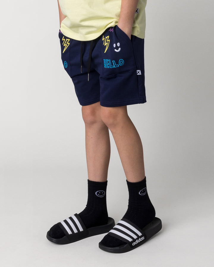 Kid wearing the Badges Short in ink, front view close up