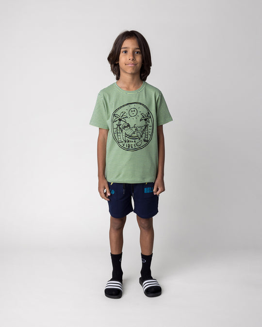 Kid wearing the Badges Short in ink with the Chill Sloth Tee in lime stripe, front view