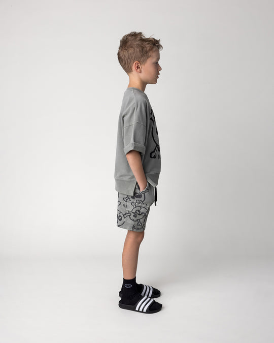 Kid wearing the Hello Skull Short in grey wash with the Hello Skull Short Sleeve Crew in grey wash, side view