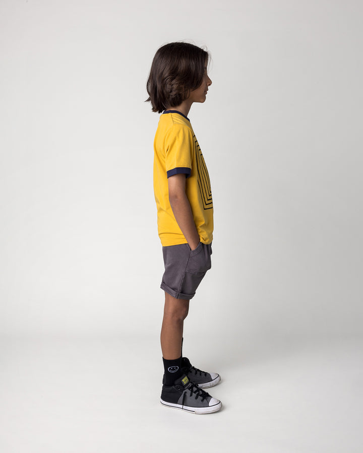 Kid wearing the Blasted Roller Short in black wash with the Hidden Panda Tee in mustard and ink, side view