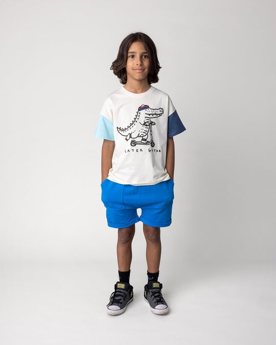 Kid wearing the Roller Short in cobalt with the Later Gator Tee in cream and blues, front view