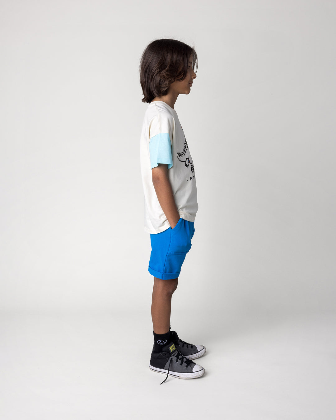 Kid wearing the Roller Short in cobalt with the Later Gator Tee in cream and blues, side view