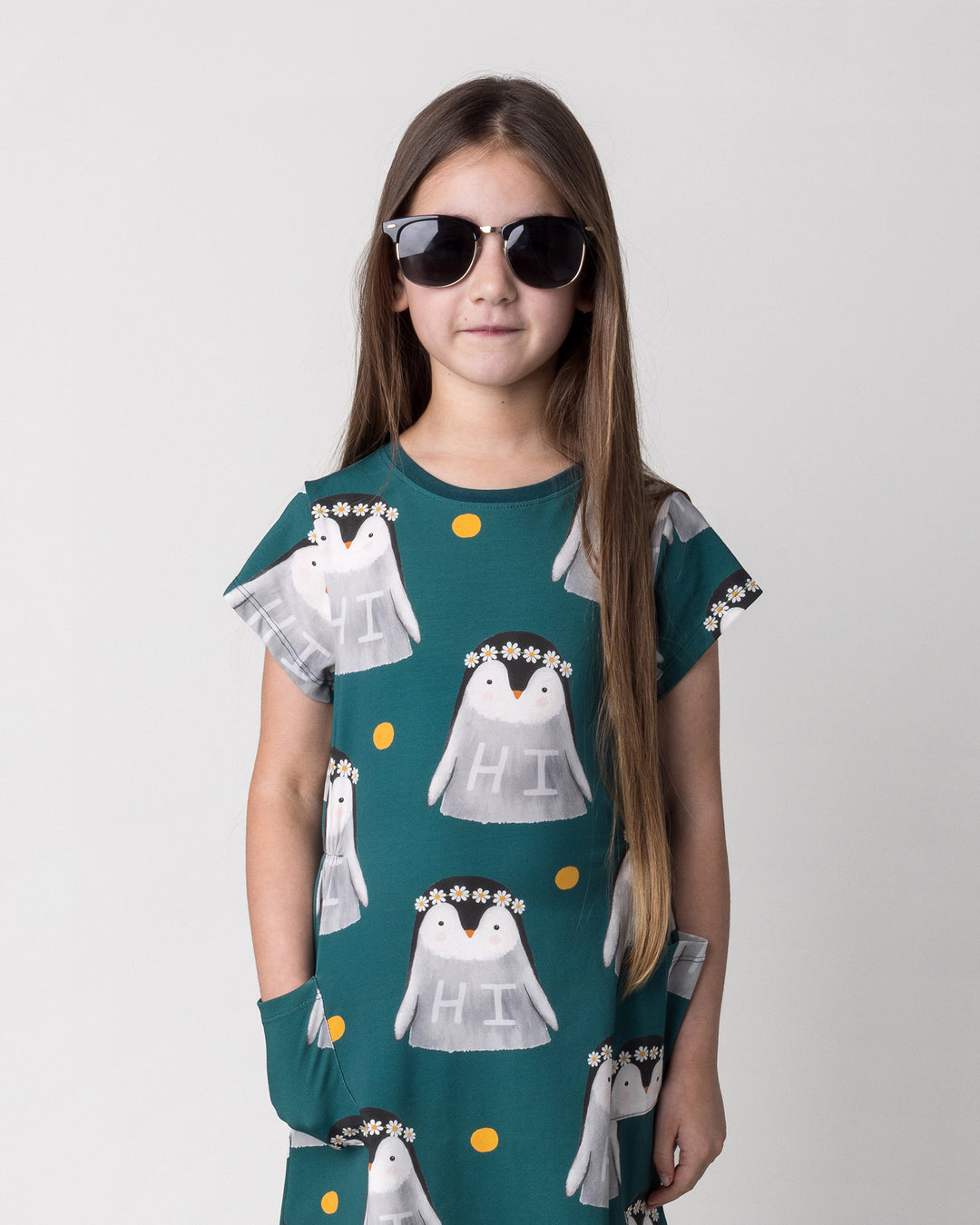 Close up of the Flower Penguin Dress in dark green on a kid, front view