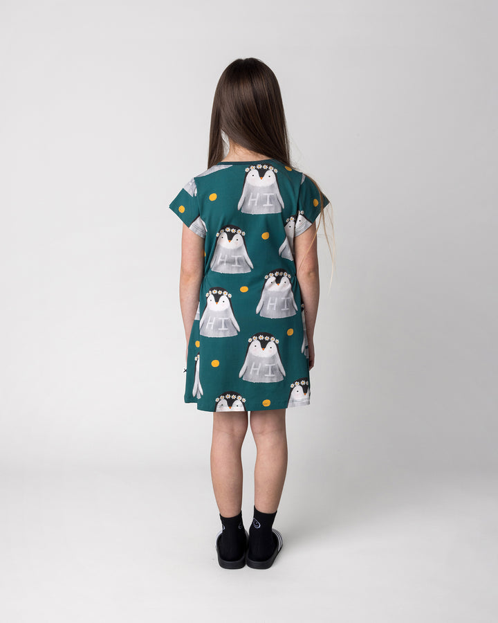 Kid wearing the Flower Penguin Dress in dark green, back view