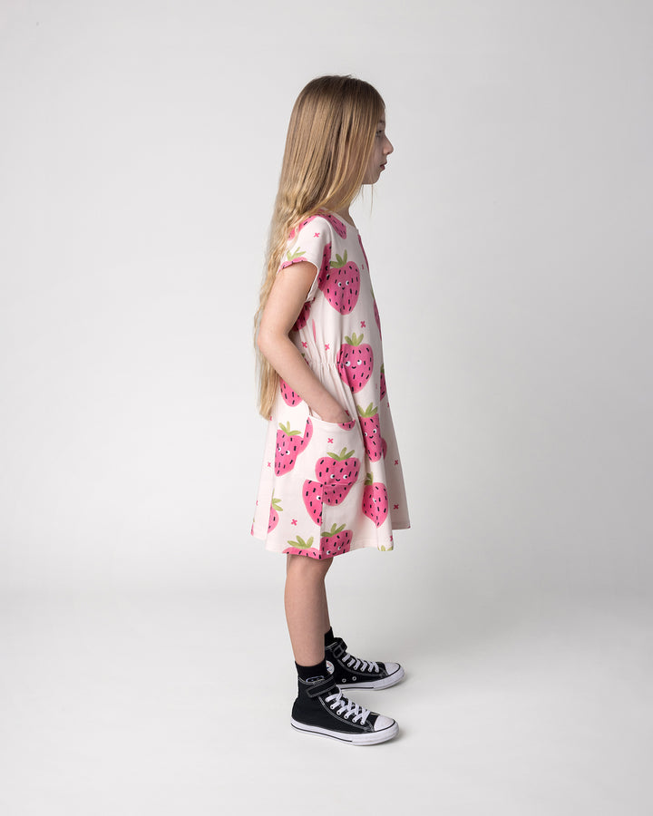 Kid wearing the Happy Strawberry Dress in cream, side view