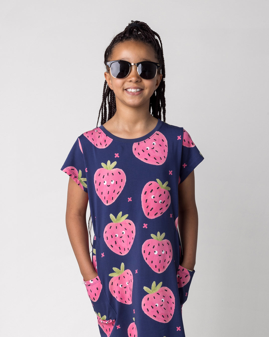 Close up of the Happy Strawberry Dress in turquoise on a kid, front view