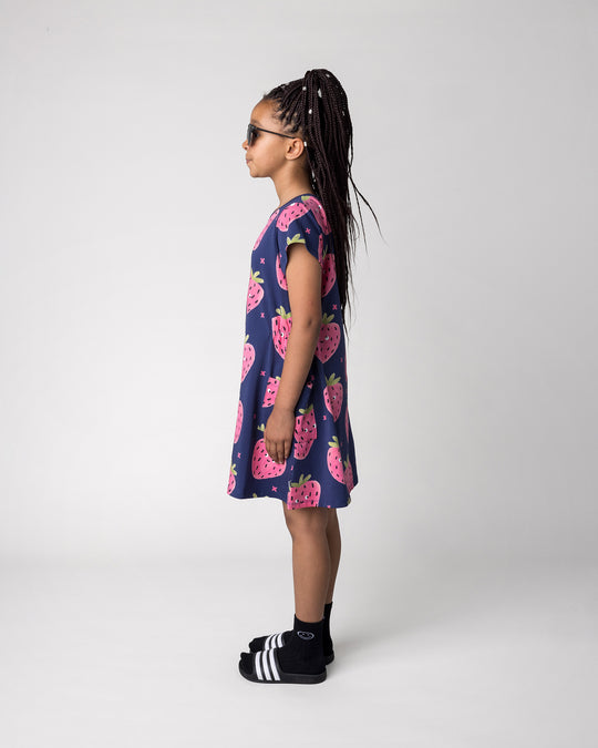 Kid wearing the Happy Strawberry Dress in turquoise, side view