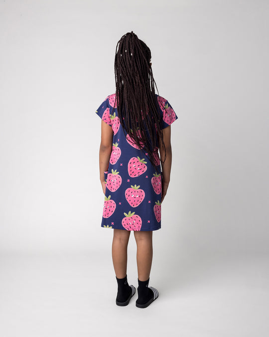 Kid wearing the Happy Strawberry Dress in turquoise, back view
