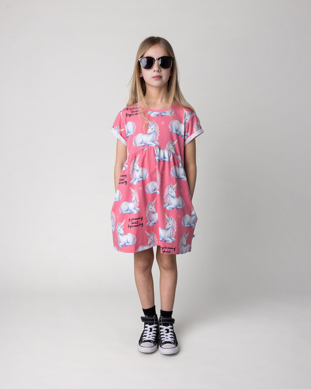 Kid wearing the Daydreaming Unicorn Dress in candy, front view