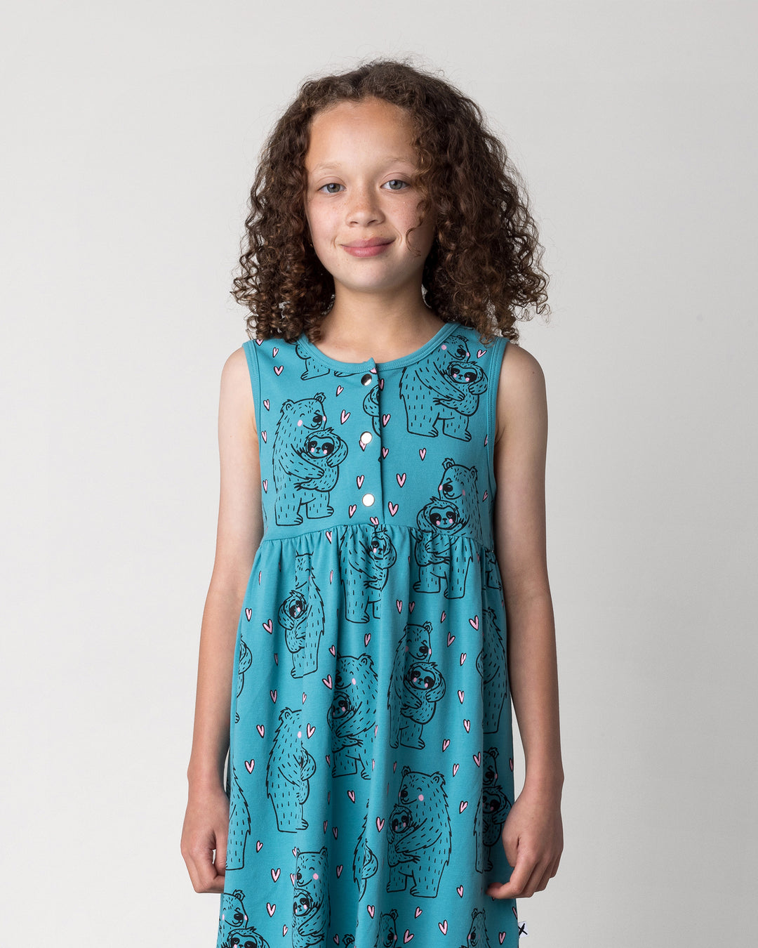 Close up of the Bear Hug Dress in emerald on a kid, front view
