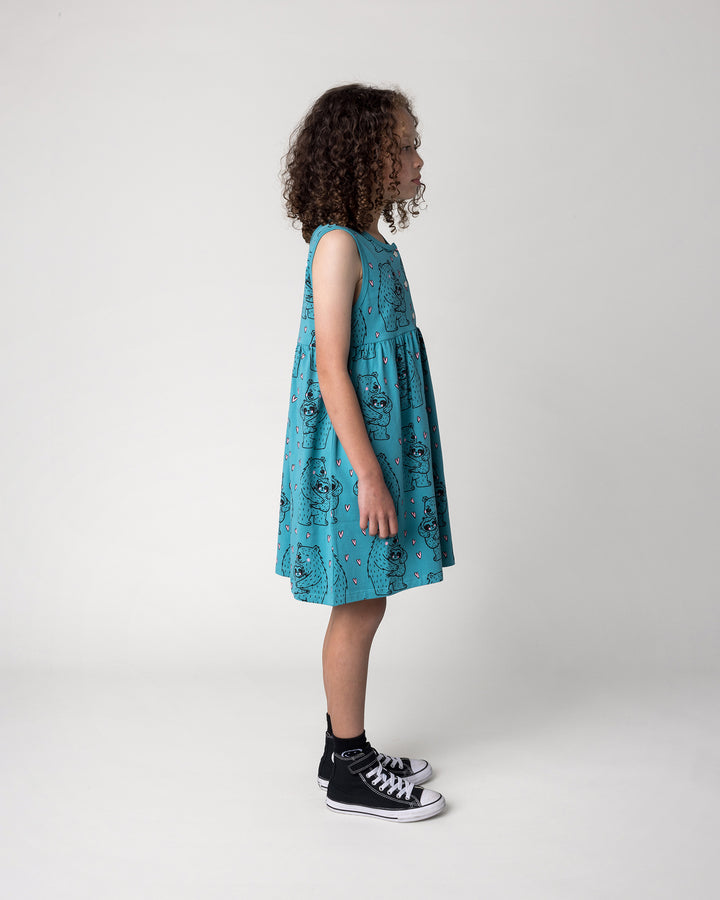 Kid wearing the Bear Hug Dress in emerald, side view