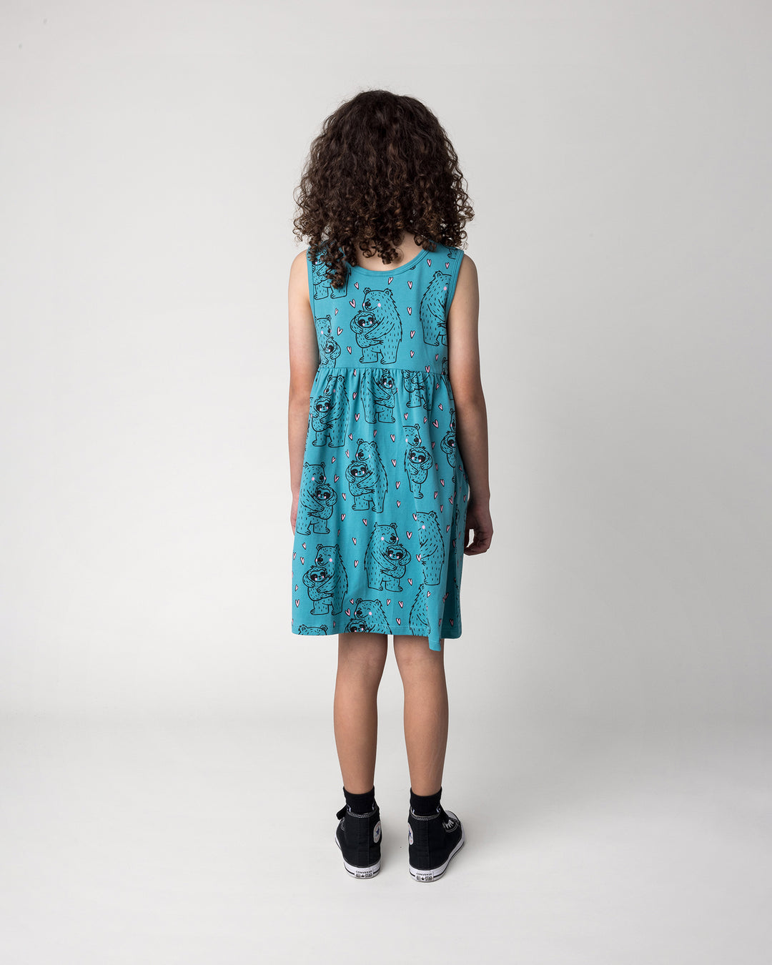 Kid wearing the Bear Hug Dress in emerald, back view