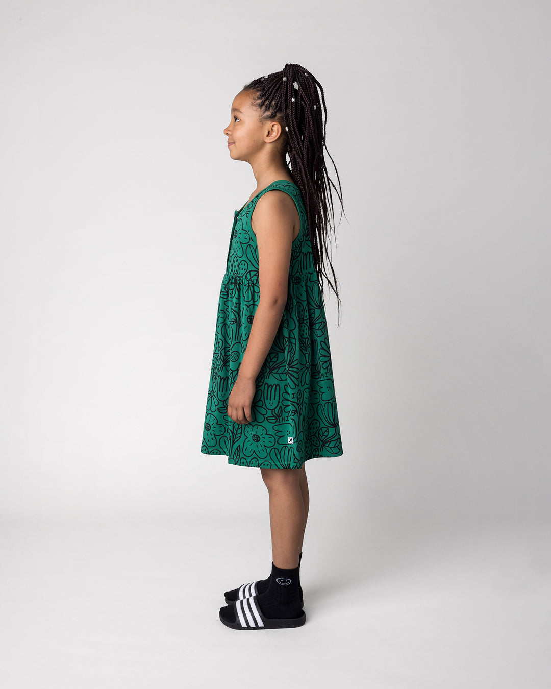 Kid wearing the Big Flowers Dress in kelly green, side view