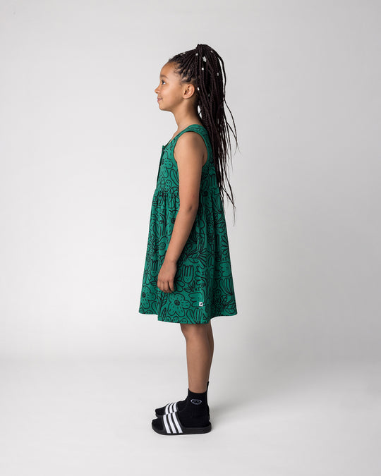 Kid wearing the Big Flowers Dress in kelly green, side view