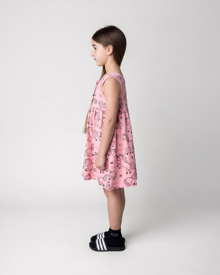 Kid wearing the Hello Unicorns Dress in pink, side view