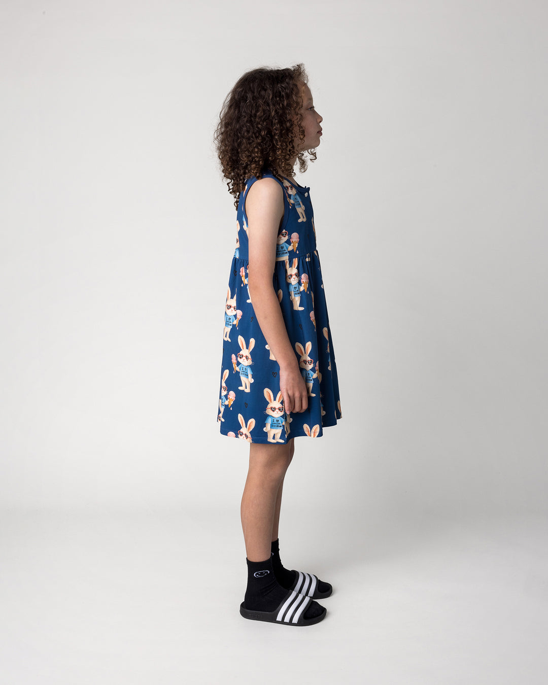 Kid wearing the Icecream Bunny Dress in blue, side view