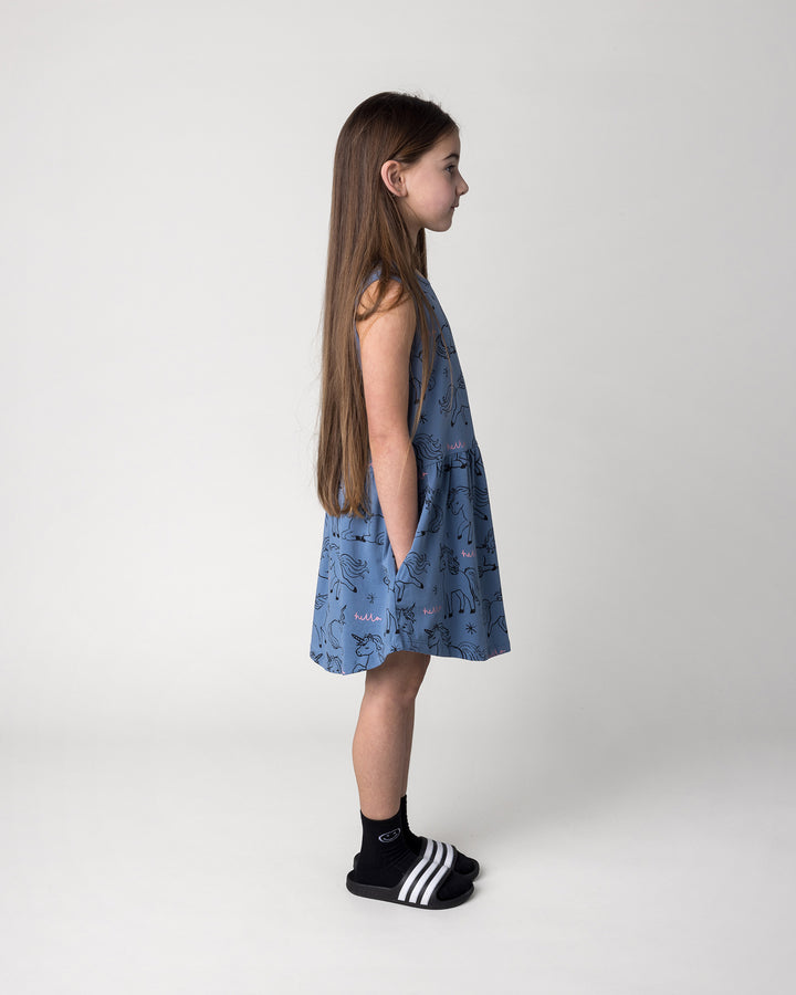 Kid wearing the Hello Unicorns Dress in mid blue, side view