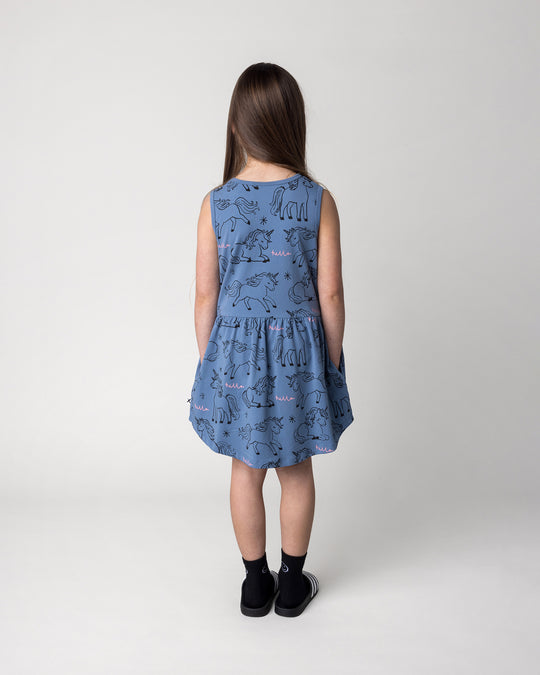 Kid wearing the Hello Unicorns Dress in mid blue, back view