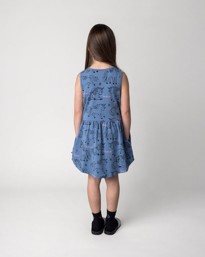Kid wearing the Hello Unicorns Dress in mid blue, back view