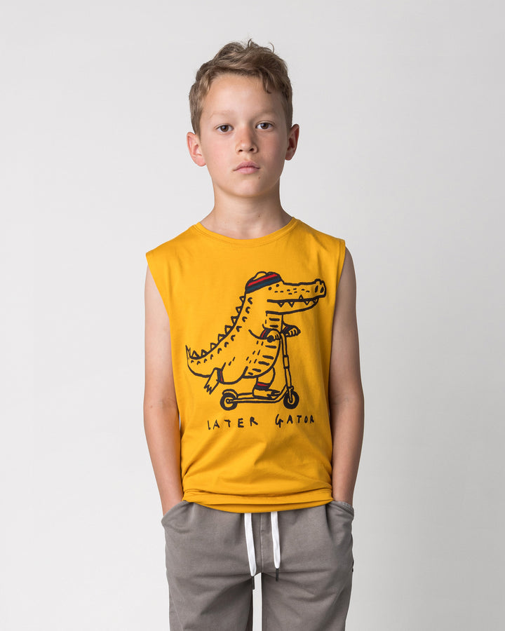 Close up of the Later Gator Sleeveless Tee in mustard on a kid, front view