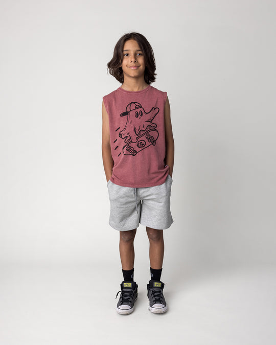 Kid wearing the Skate Ghost Sleeveless Tee in burnt red wash with the Smile Short in grey marle, front view