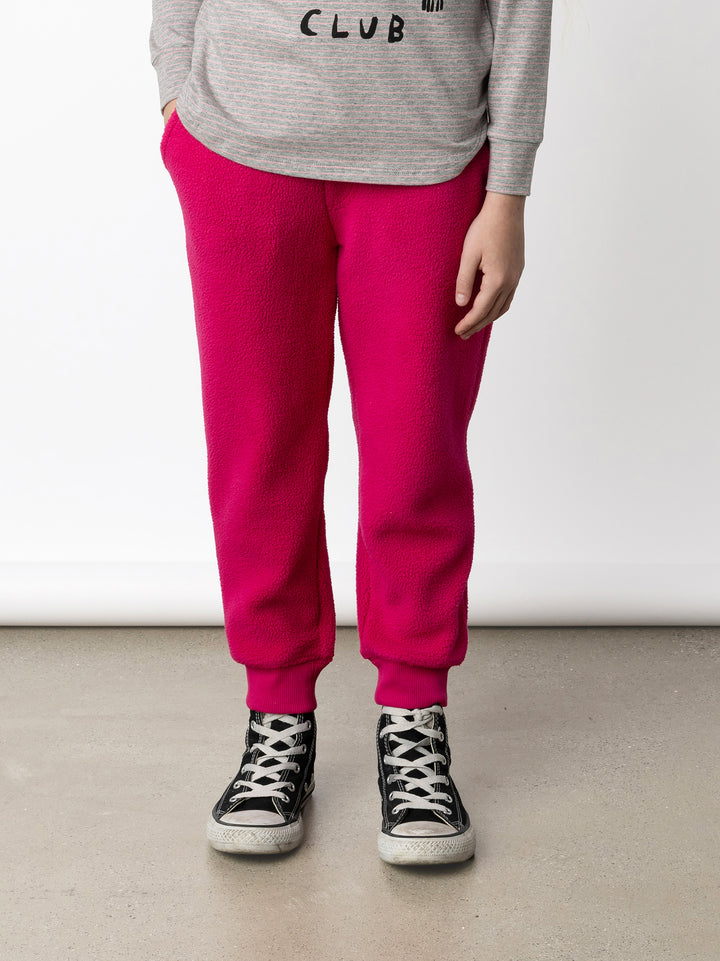 Minti kids clothing. Super cosy and soft loose leg trackies made in teddy with 2x2 rib cuffs. Front pocket to keep hands warm. Small Minti embroidery on the back. 70% Polyester // 30% Cotton.