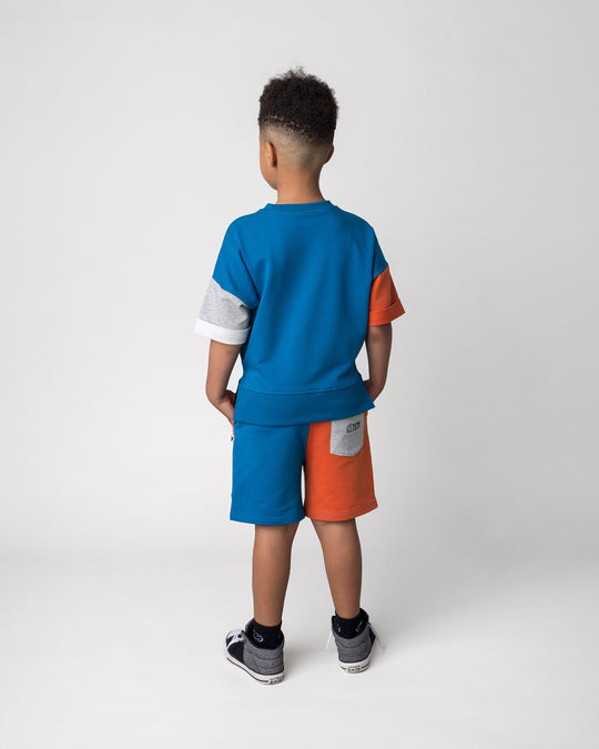 Kid wearing the Sliced Short in teal, orange and grey marle with the Chill Sloth Short Sleeve Crew in teal, orange and grey marle, back view