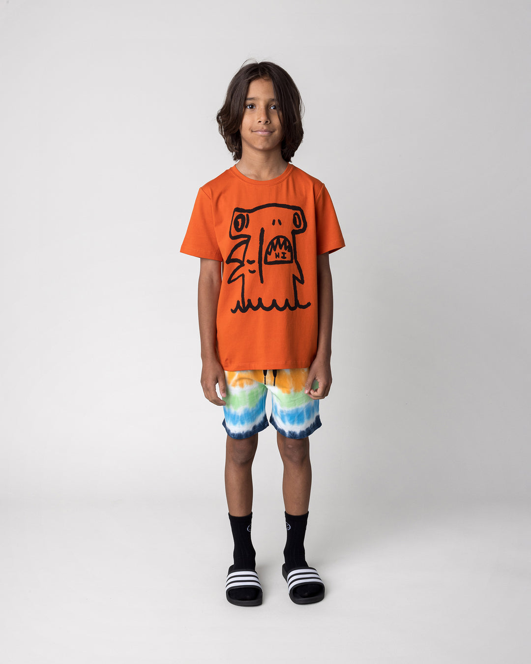 Kid wearing the Airwaves Short in navy with the Hi Hammerhead Tee in orange, front view