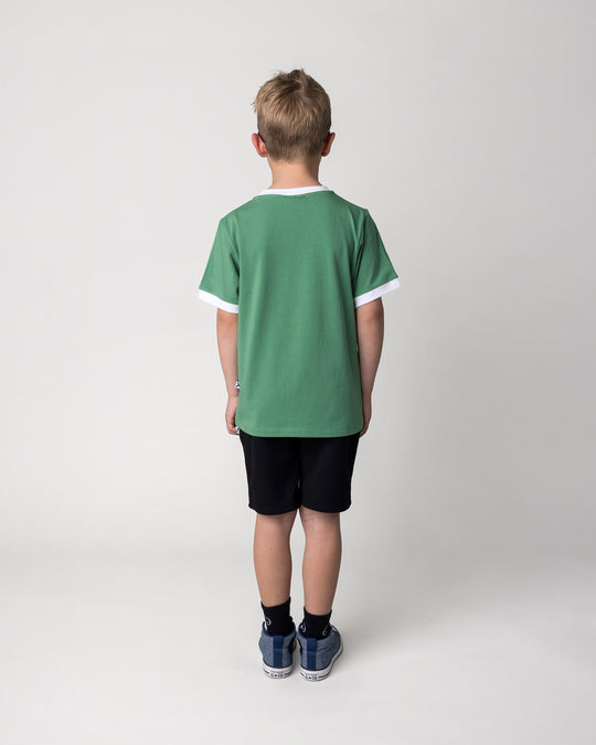 Kid wearing the Hero Short in black with the Hidden Panda Tee in turf and white, back view