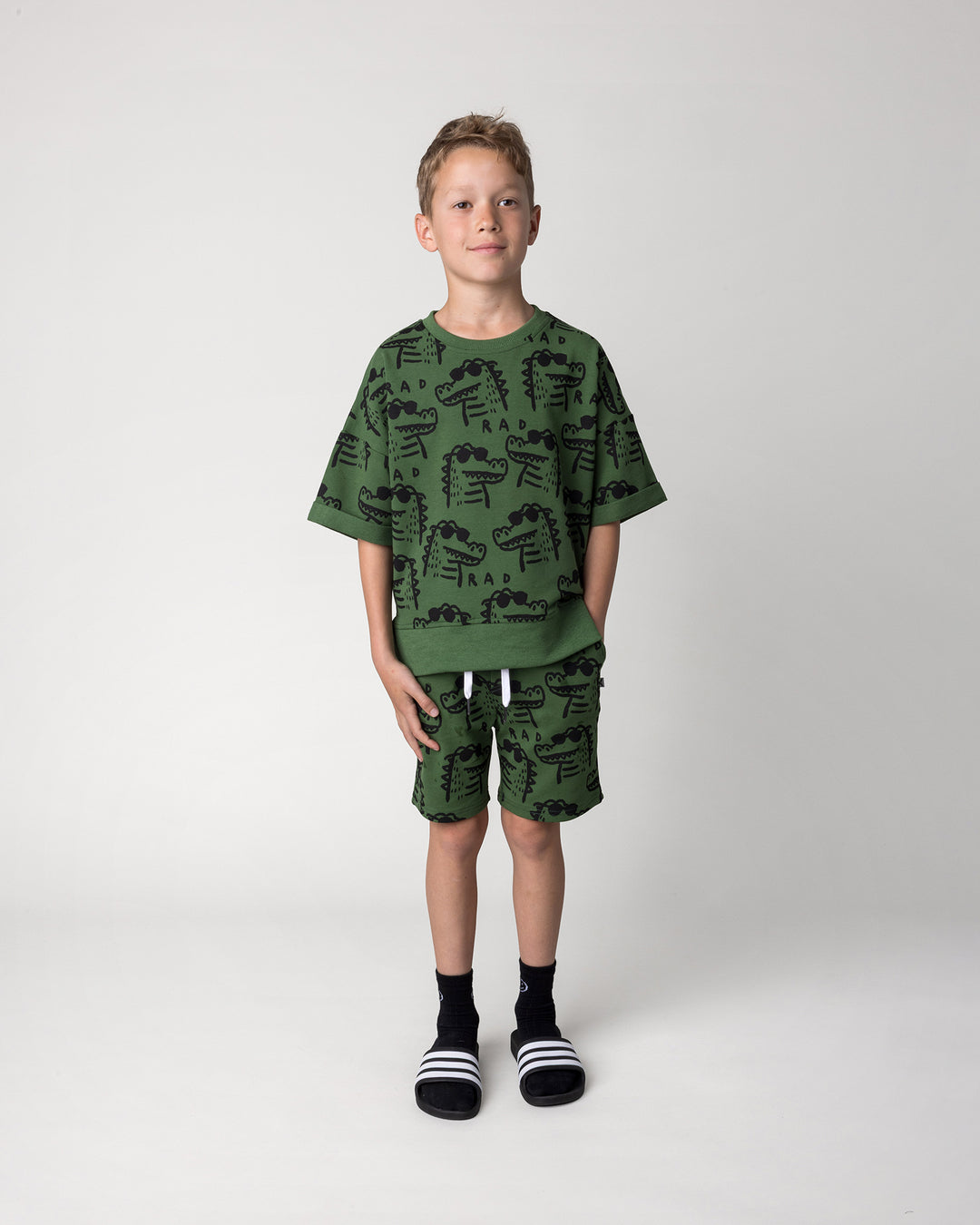 Kid wearing the Rad Croc Short in green with the Rad Croc Short Sleeve Crew in green, front view