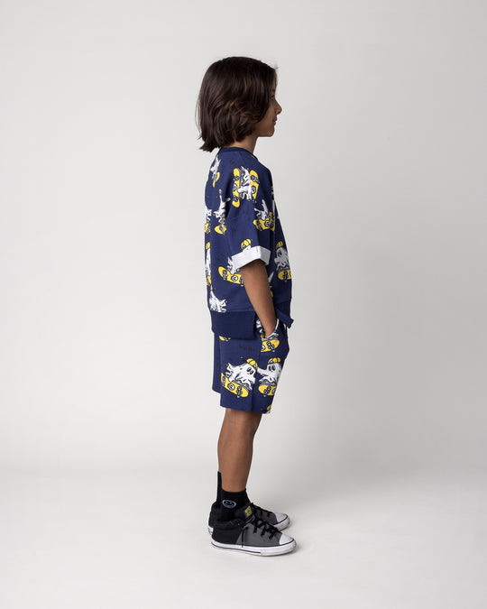 Kid wearing the Skate Ghost Short in dark blue with the Skate Ghost Short Sleeve Crew in dark blue, side view