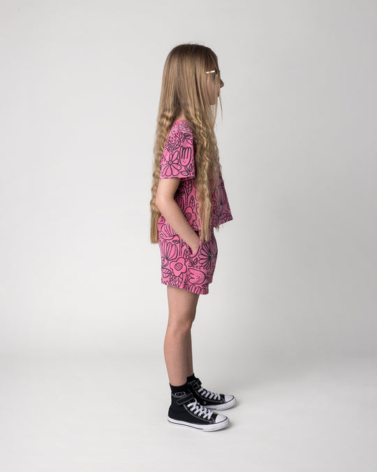 Kid wearing the Big Flowers Cropped Tee in pink wash with the Big Flowers Short in pink wash, side view