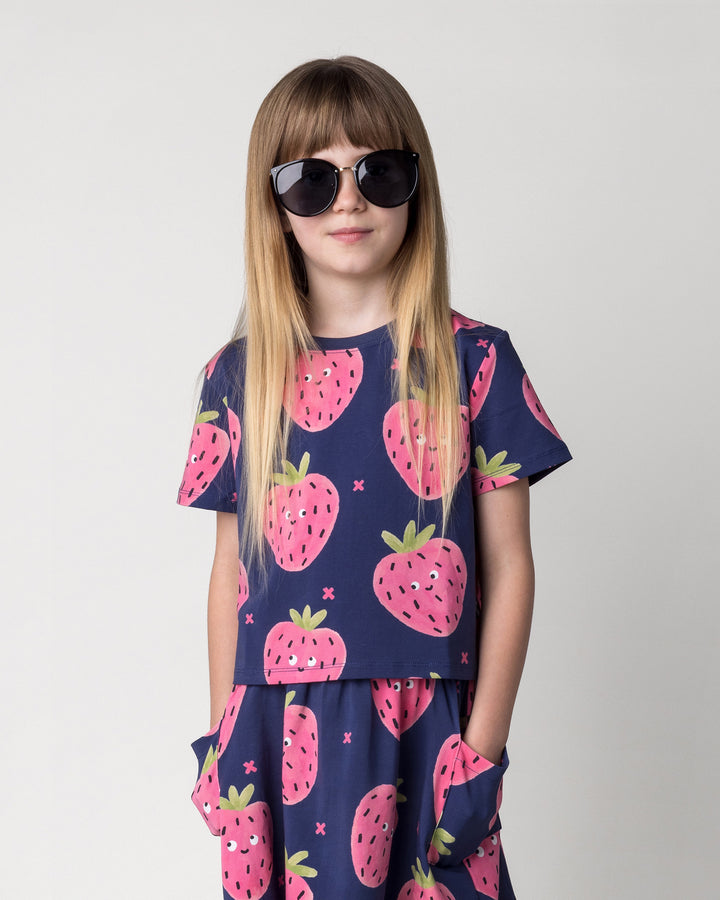 Close up of the Happy Strawberry Cropped Tee in turquoise on a kid, front view