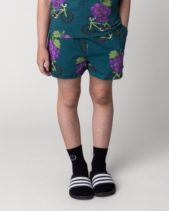 Kid wearing the Biking Grape Short in dark teal, front view close up