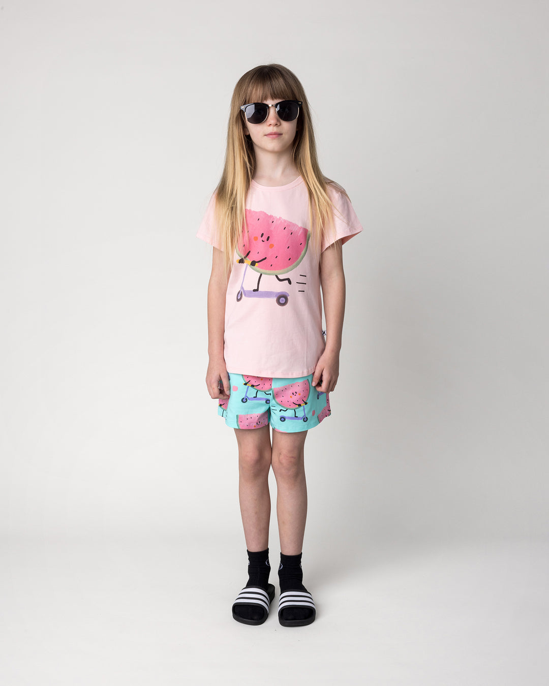 Kid wearing the Scooting Watermelon Short in light mint with the Scooting Watermelon Tee in light pink, front view