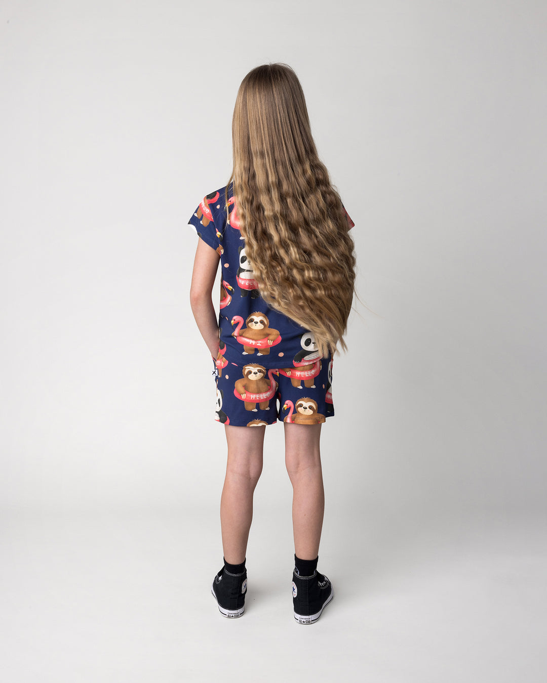 Kid wearing the Swimming Buddies Short in midnight with the Swimming Buddies Tee in midnight, back view