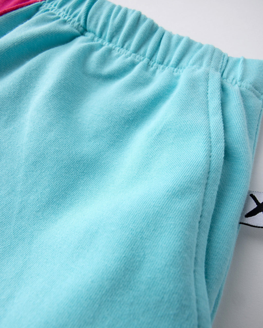 Close up detail of the Two Tone Short in hot pink and aqua