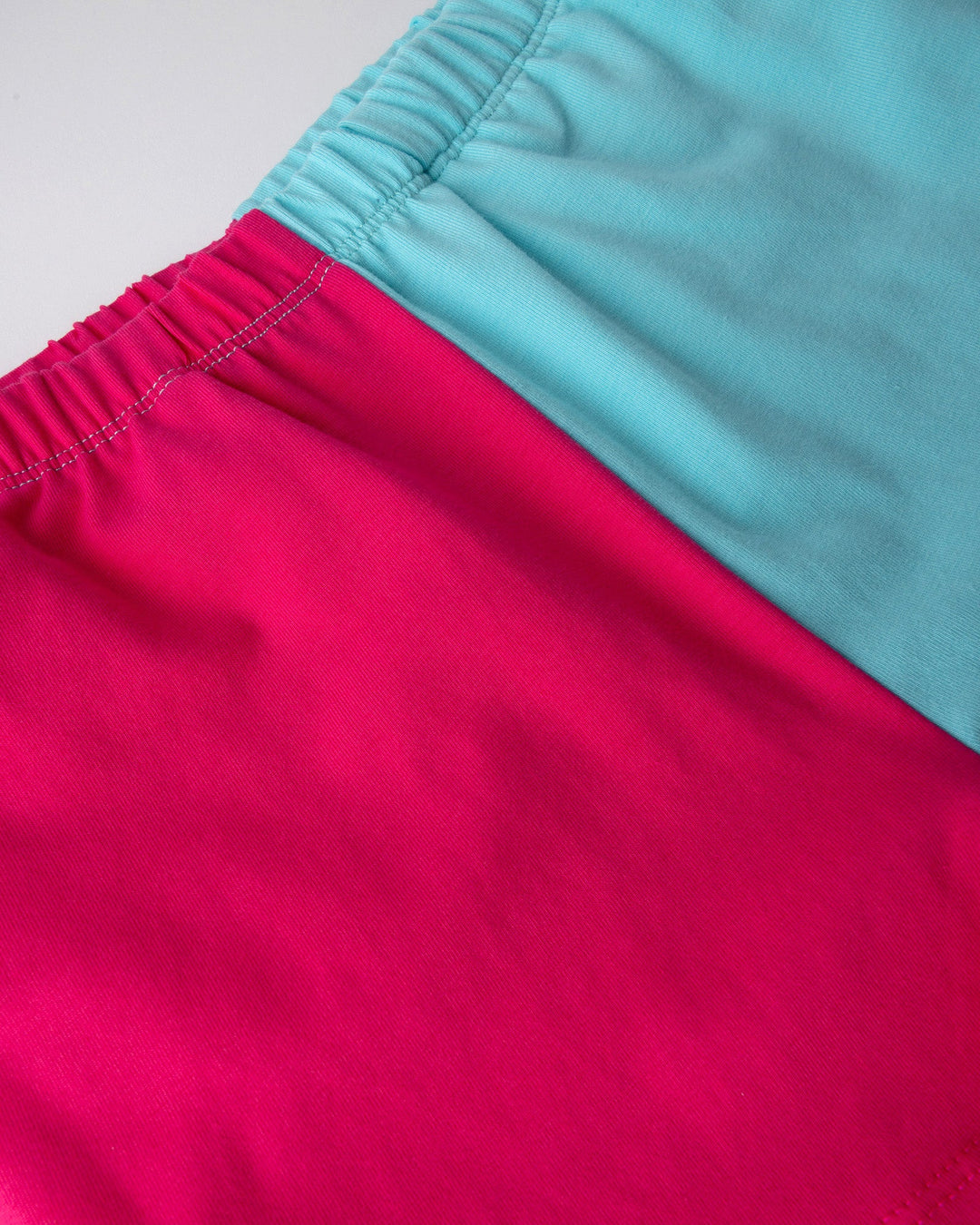 Close up detail of the Two Tone Short in hot pink and aqua