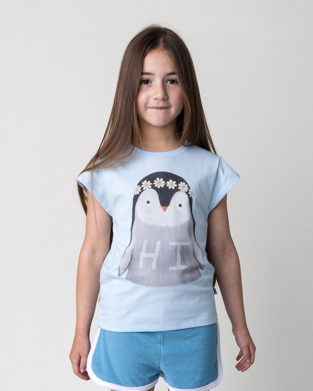 Close up of the Flower Penguin Tee in light blue on a kid, front view