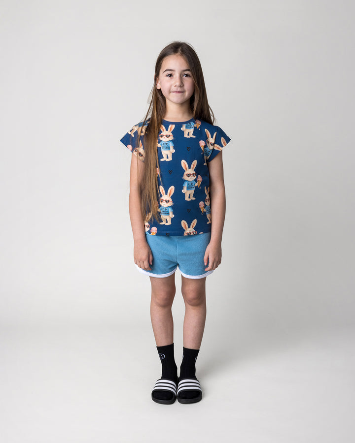 Kid wearing the Icecream Bunny Tee in blue with the Track Star Short in ocean, front view