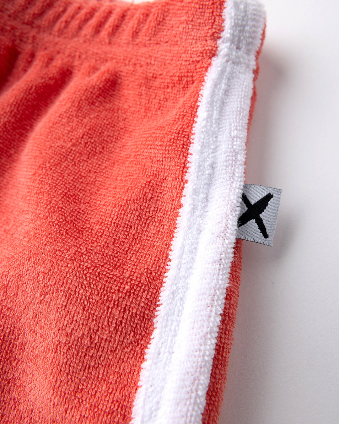 Close up detail of the Track Star Short in tangerine