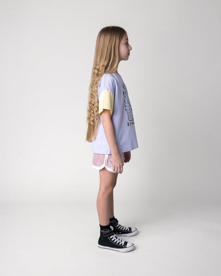 Kid wearing the Velvet Runner Short in blush and cream with the Bear Hug Tee in lilac, lemon and blue, side view