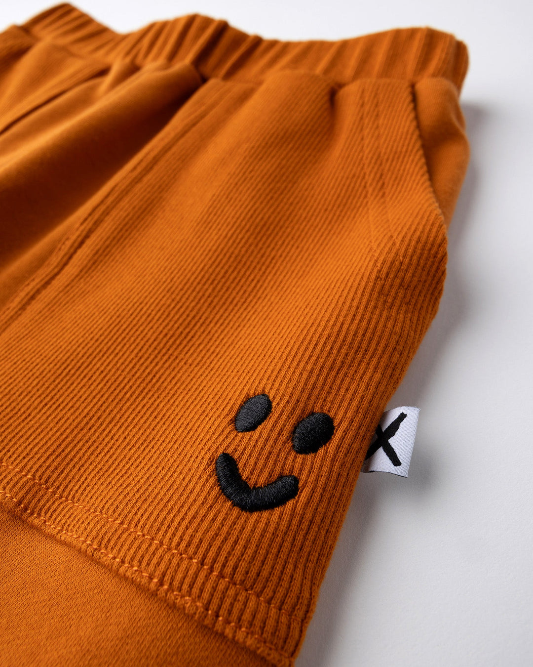 Close up detail of the Rib Pocket Short in burnt orange