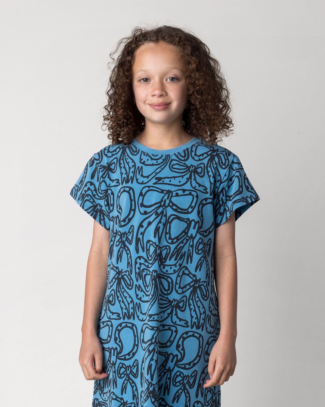 Close up of the Big Bows Dress in blue wash on a kid, front view