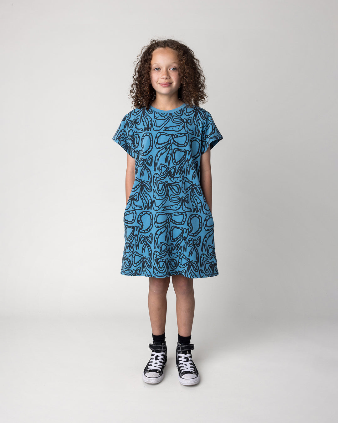 Kid wearing the Big Bows Dress in blue wash, front view