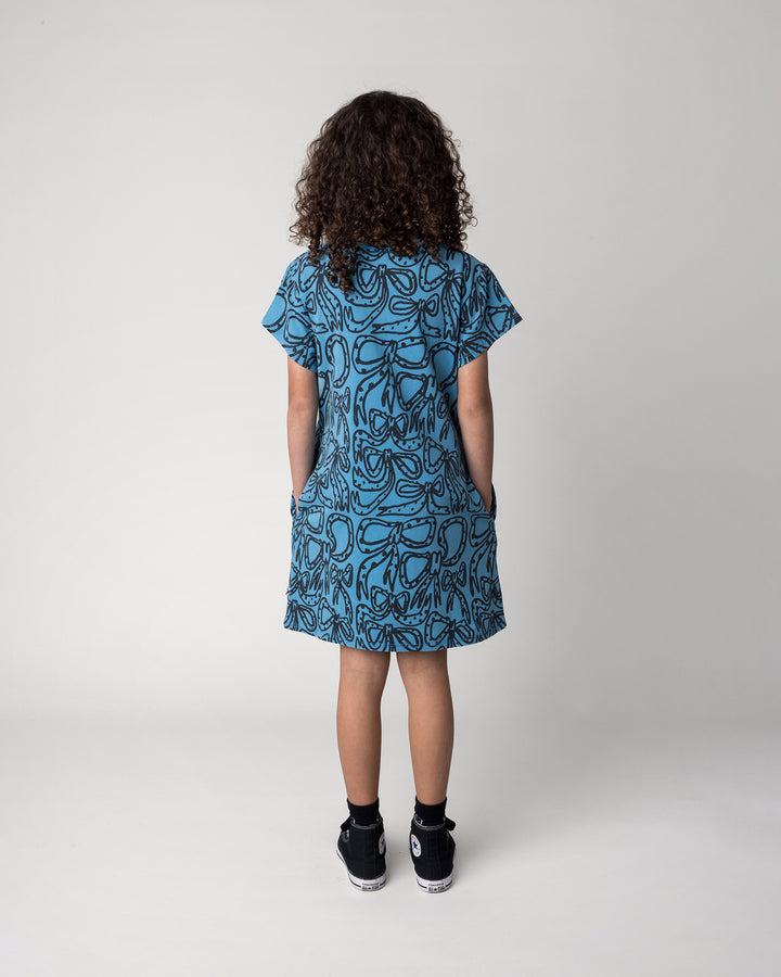 Kid wearing the Big Bows Dress in blue wash, back view
