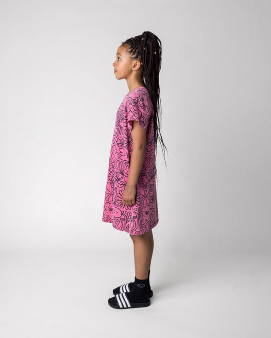 Kid wearing the Big Flowers Dress in pink wash, side view