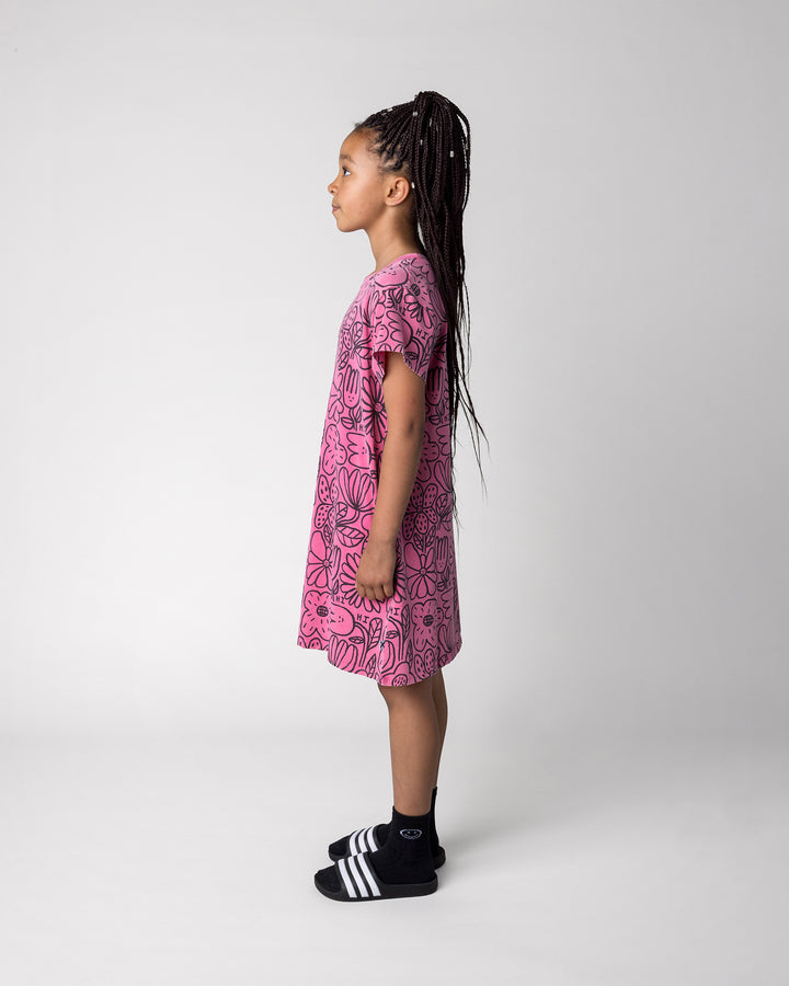 Kid wearing the Big Flowers Dress in pink wash, side view