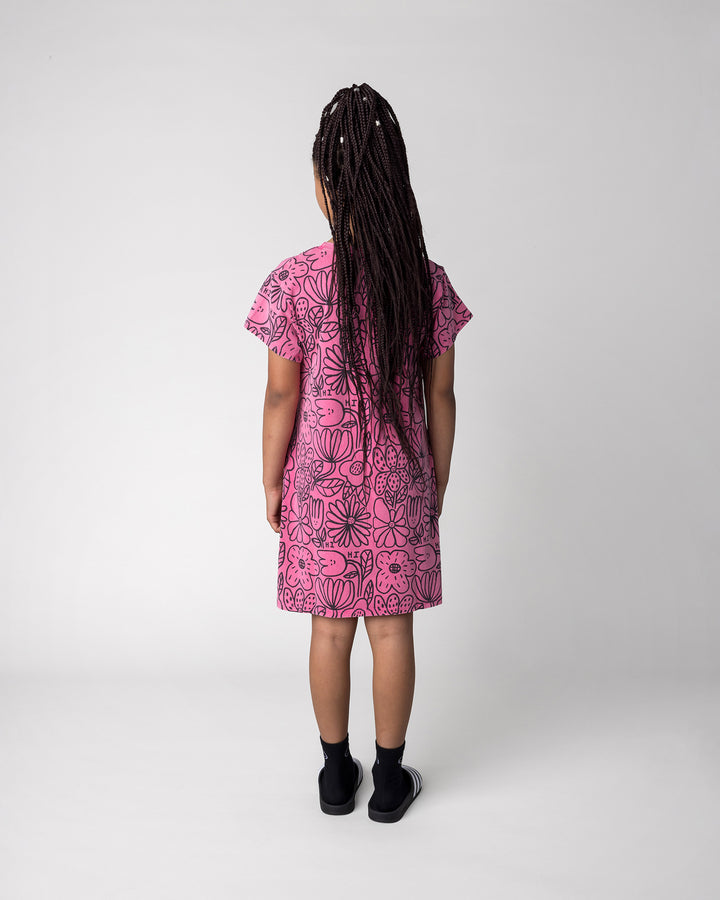 Kid wearing the Big Flowers Dress in pink wash, back view